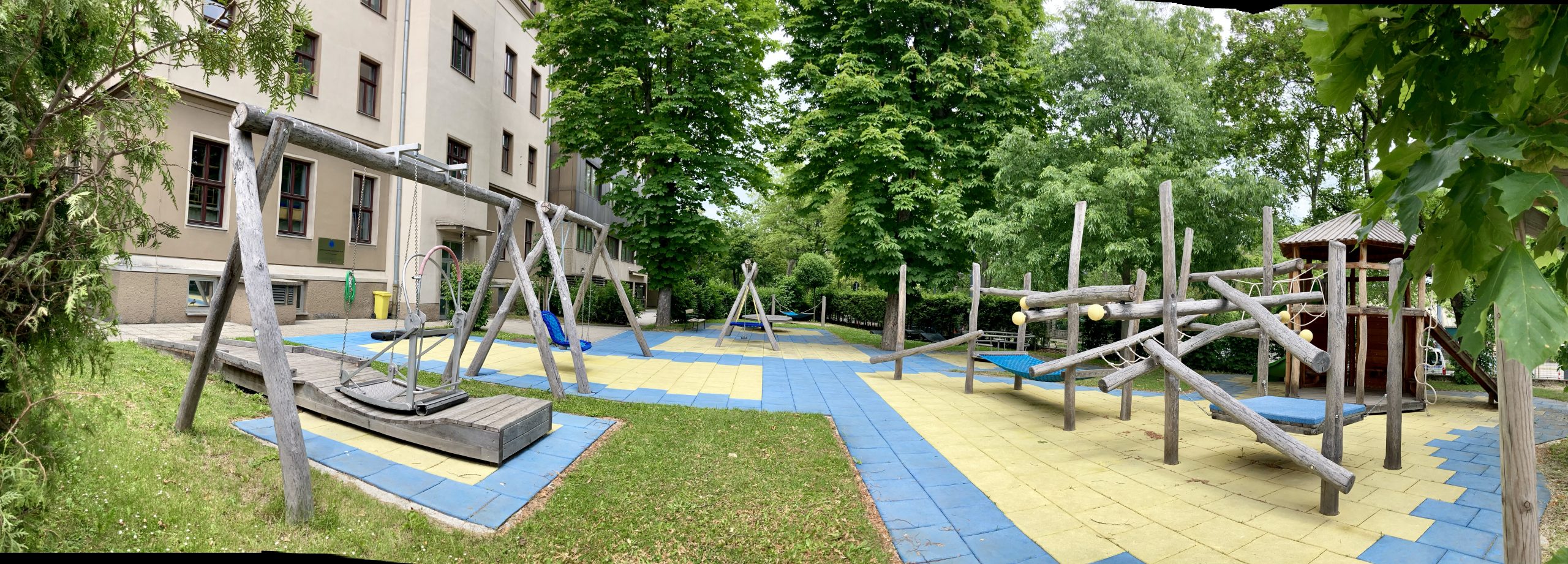 Schulgarten mit Rollstuhlschaukel, Nestschaukel, Klettergerüst und Rutsche
