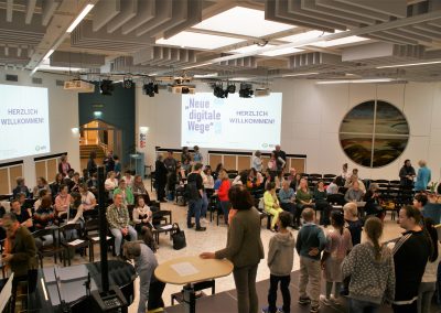 Aula mit Tagungsteilnehmer*innen und Chor