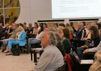 Tagungsteilnehmer*innen bei Vortrag in Aula (Mag. Erich Schmid vorne sitzend)