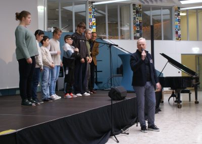 Joy-Chor auf der Bühne. Direktor Ganitzer begrüßt die Tagungsteilnehmer.