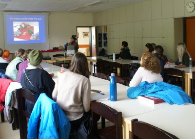 Workshop 3 von Mag. Reisenberger. Blick über die Teilnehmer*innen auf die Präsentations-Leinwand. Frau Mag. Reisenberger steht rechts von dieser.