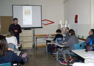 Workshop 6 von Mag. Hill. Er steht vor den Workshop-Teilnehmer*innen und projiziert die Ansicht seines iPhones auf eine Leinwand.